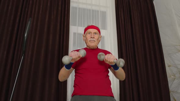 Senior Elderly Man in Sportswear Doing Weight Lifting Dumbbells Workout Cardio Exercising at Home