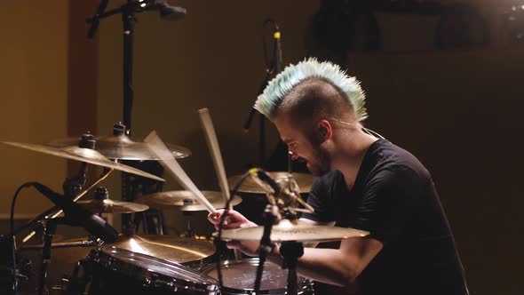 Hard rock drummer performing in a studio setting.