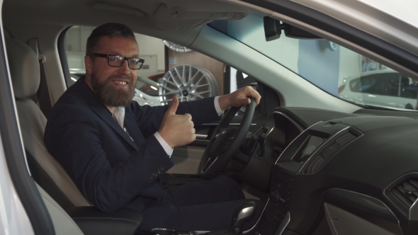 Male Customer Approves Car Interior at the Dealership