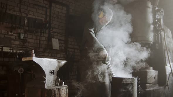 Blacksmith Cooling Out Hot Metal Detail in the Bucket of Cool Water