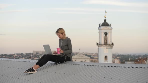 Sitting on the rooftop, with laptop and coffee cup