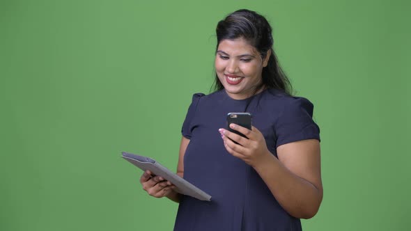 Young Overweight Beautiful Indian Businesswoman Against Green Background