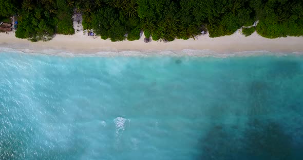 Tropical fly over tourism shot of a white paradise beach and aqua blue water background in vibrant 4