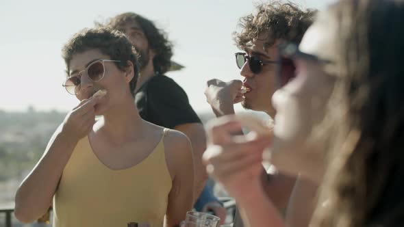 Joyful Man and Women Tasting Homemade Pizza on Rooftop Party