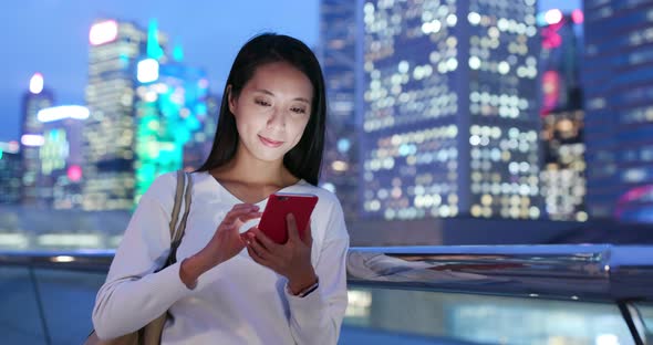 Woman use of mobile phone in city at night