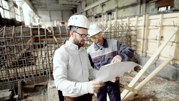 Architect and Chief Foreman at the Construction Site of the Plant. Men Discuss Drawbacks in the