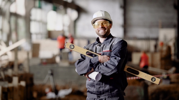 Foreman at the Construction Site. A Man Dressed in a Special Uniform and Wearing a Helmet on His
