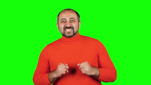 Plump Caucasian Man Rejoices Victory or Win What He Sees. Green Screen. Slow Motion