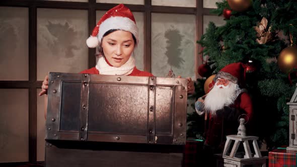 Asian Girl in Hat Opening a Chest with Gifts