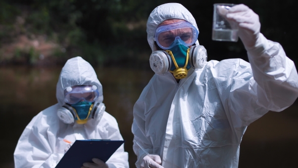 Two Ecological Workers in Biohazard Suits Testing Water