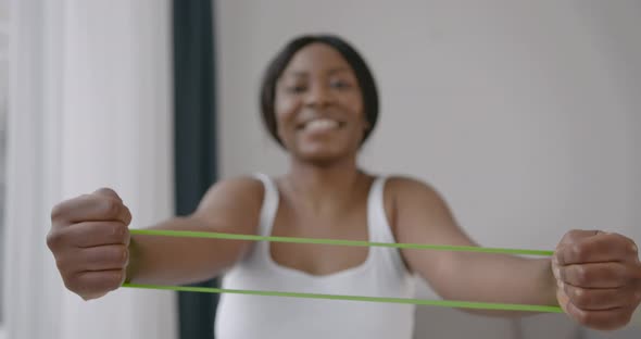 Woman in Sportswear Exercising with Rubber Resistance Band