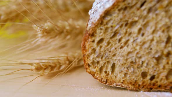 Dark Bread Cut Into Slices on a Wooden Board with Breadcrumbs Closeup