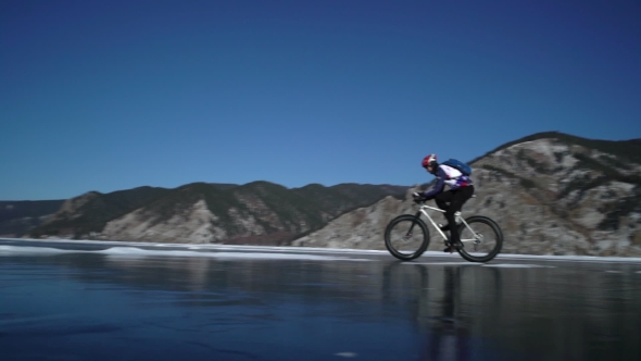 Men Riding a Bicycle on the Surface of Frozen Lake