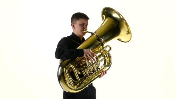 Man Plays on the Tuba Slow Melody. White Studio Background