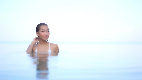 Young asian woman enjoy around outdoor swimming pool for leisure