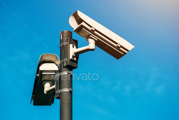 surveillance security cameras against blue sky that symbolizes freedom