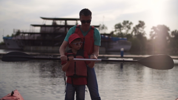 The Father Teaches the Son How To Use an Oar in a Kayak