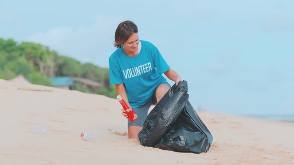 Young Caucasian Woman Removing Garbage and Throwing Bottles From Beach