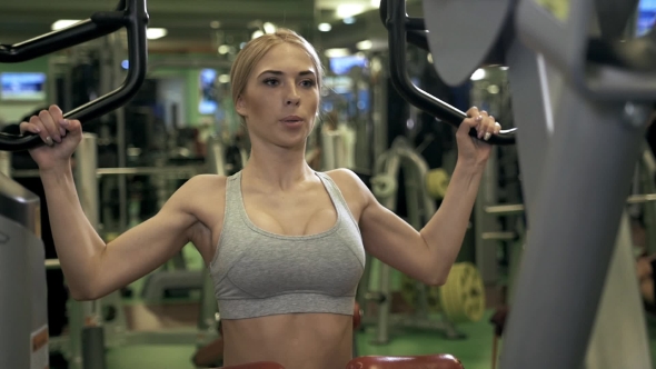 Young Fitness Woman Execute Exercise with Exercise-machine in Gym