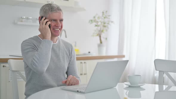 Cheerful Senior Old Man Talking on Smartphone at Home