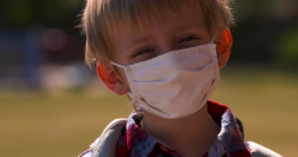 Outdoor portrait of a school boy in a face mask.