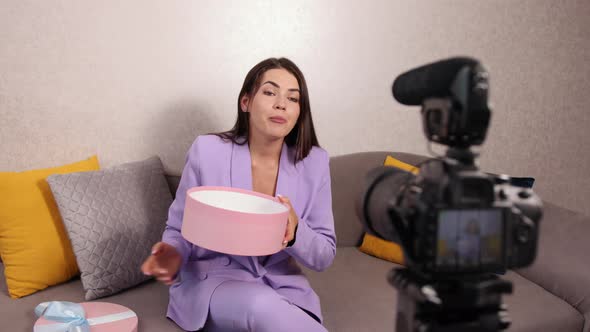 Woman Sitting on Sofa in Front of Smartphone on Tripod at Home