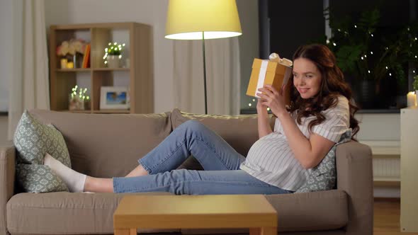 Happy Smiling Pregnant Woman with Gift Box at Home