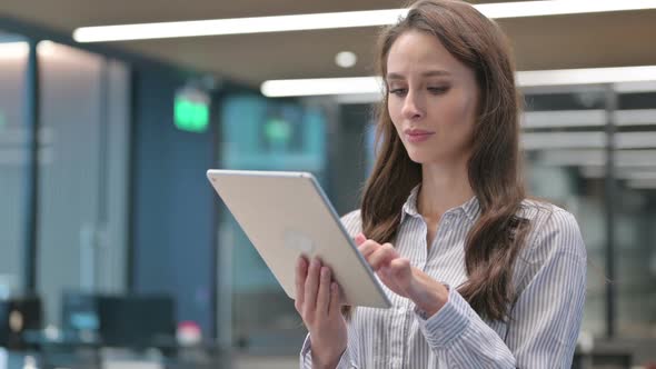 Portrait of Young Businesswoman Celebrating Success on Tablet