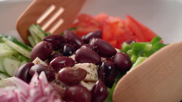 Camera follows tossing greek salad. Slow Motion.