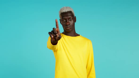 African Man in Yellow Disapproving with No Finger Sign Make Negation Gesture. Denying, Rejecting