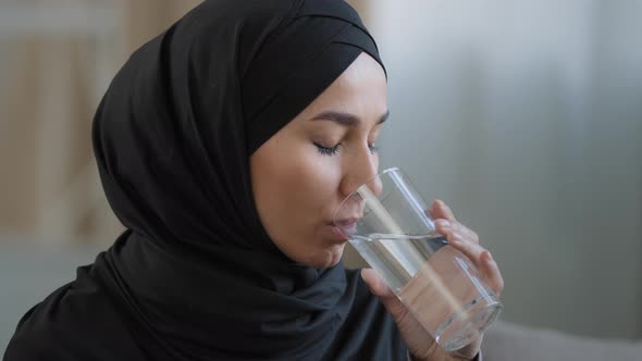 Close Up Arabian Young Woman with Perfect Skin in Hijab Drinking Glass of Clear Filtered Water