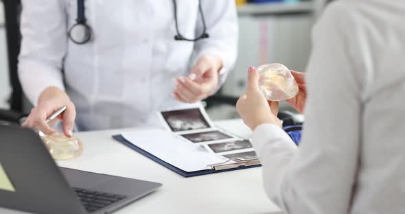 Doctor Hands Breast Silicone Implant to Woman in Clinic