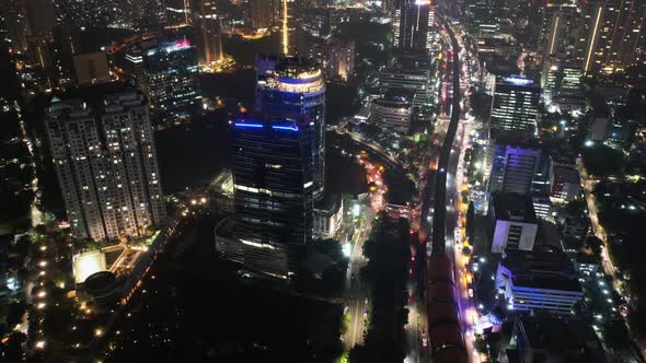 Aerial view of timelapse highway intersection and buildings in the city of Jakarta