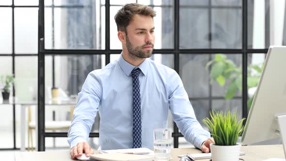 Businessman feels overjoyed looks at computer. Happy man reads good news using PC, business success