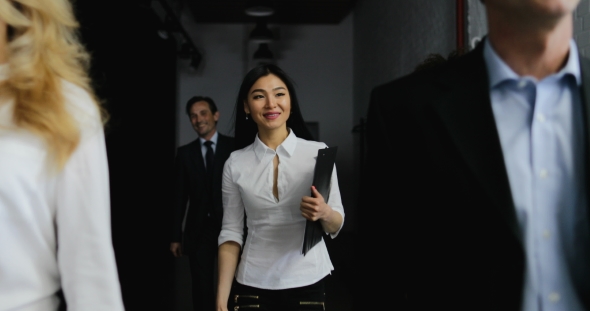 Team Of Business People Walking In Office While Asian Businesswoman Answer Phone Call