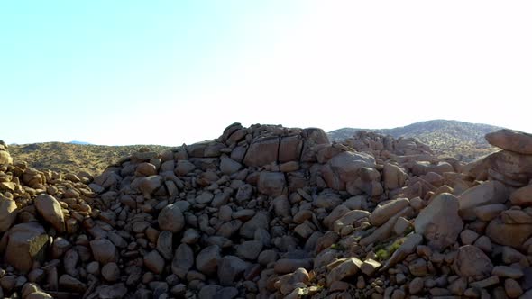 Drone shot flying away from some really big rocks and boulders.