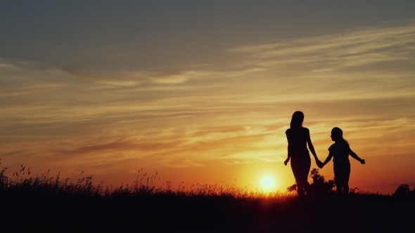 Silhouette of Joyful Girlfriends at Sunset