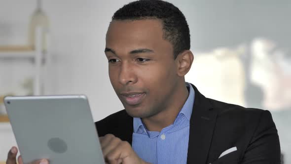 Close Up Of Casual AfroAmerican Businessman Celebrating Success While Using Tablet