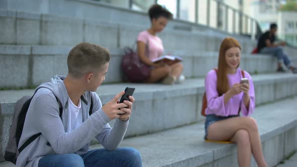 Male Female Teenagers Chatting Smartphone Sitting Beside, Online Communication