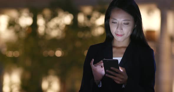 Woman Looking at Mobile Phone in City 