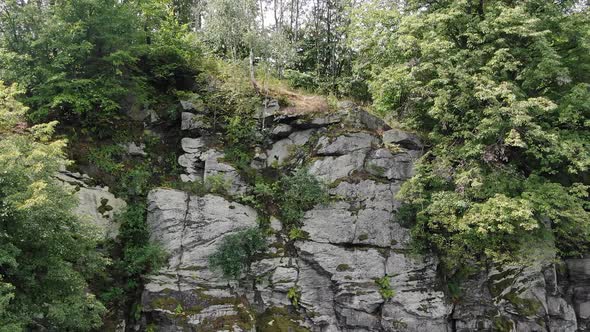 Aerial View of Rocky Cliffside of Mountain Surrounded by Green Trees