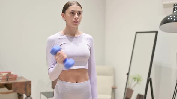 Young Latin Woman Working Out with Dumbbells at Home