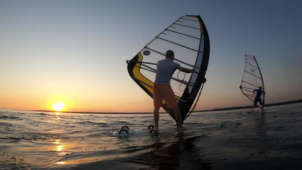 Two Men Are Catching Wind While Sailing on Windsurf Boards