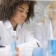 Woman Scientist Working With Microscope While Her African American Colleague Making Notes Of - VideoHive Item for Sale