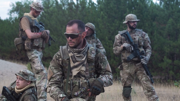 Men in Camouflage with Guns Outside