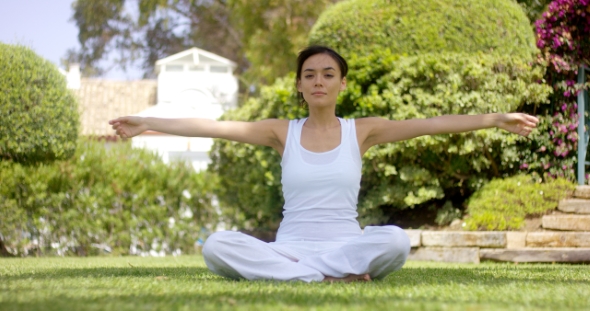 Gorgeous Young Woman in White Sitting on Lawn