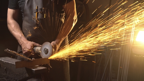 Sparks During Cutting of Metal Angle Grinder. Worker Using Industrial Grinder.