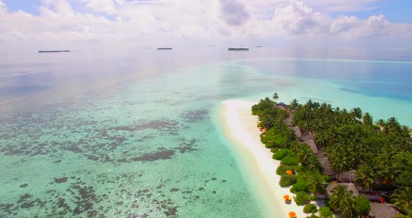 Aerial drone view of a scenic tropical island resort hotel in the Maldives