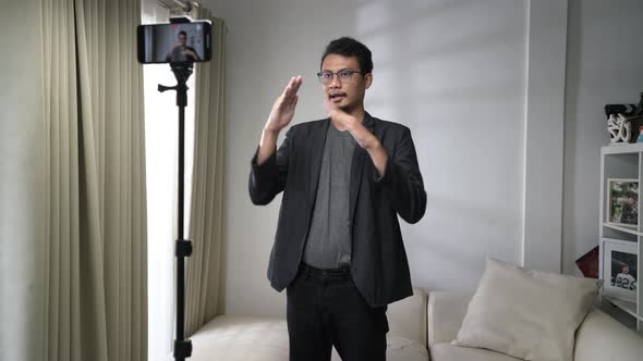 Asian man make a video call or conference with stand up and using smartphone