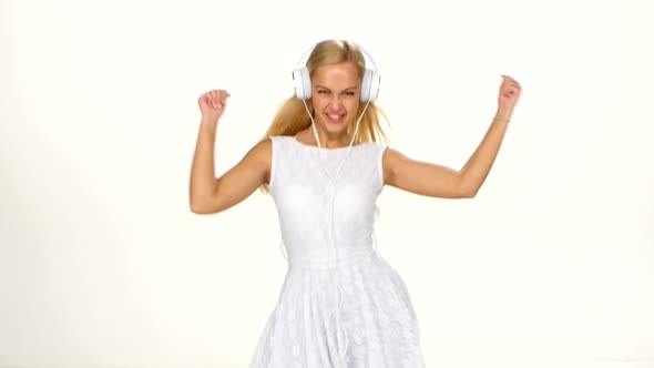 Beautiful Female in Headphones Listening To the Music with Fluttering on the Wind Hair Over White